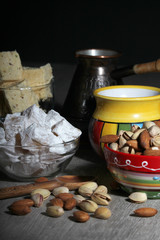 A mug of coffee and different oriental sweets: turkish delight, halva, almond and pistachio