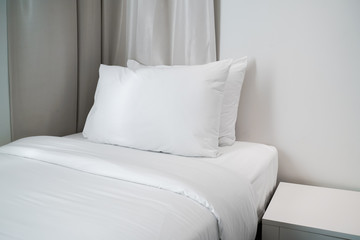 white pillow on bed with blanket in bedroom, closeup