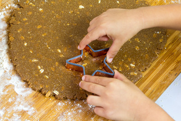 A kid Making Star Oat Christmas Cookies in the kitchen before christmas for Santa
