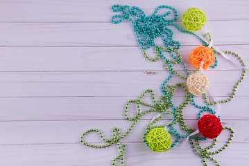 Different rattan balls, beads laying on white wooden table. Top view, copy space for text