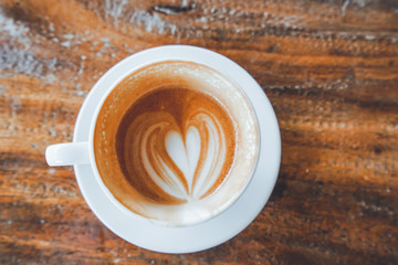 Heart shape latte art coffee on wooden table