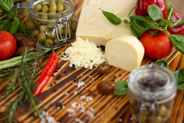 Food ingredient for italian pasta and pizza on wooden table. Fresh vegetables, cheese and seasoning for mediterranean cuisine. Food composiion from colorful vegetable and seasoning with copy space.