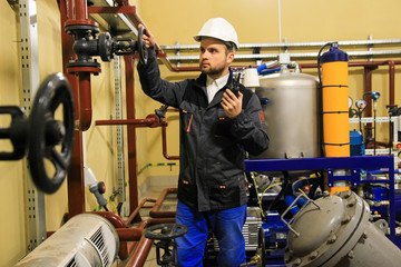 Technician engineer opens gate valve of pipeline on oil refinery