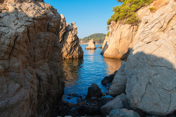 Fototapeta na wymiar Bay in mediterranean, Spain. Cliff on sea beach in Lloret de Mar