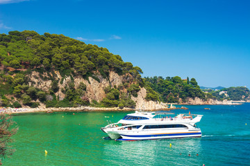 Fototapeta na wymiar White tourists yacht swims in spanish resort