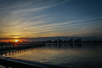 Fototapeta na wymiar beautiful sunset on the river in the city 