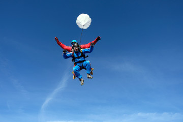 Naklejka na ściany i meble Tandem skydiving. Two happy men are in the sky.