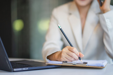 Close up hand's businesswoman making notes.