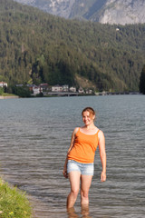 Fototapeta na wymiar beautiful girl walks by the water in summer.