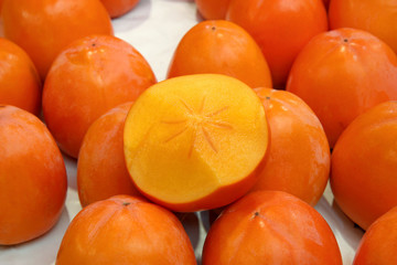 Fresh ripe persimmons placed on table in market.