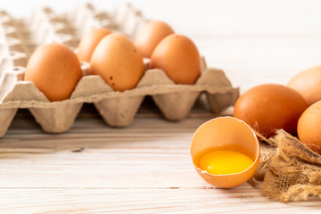 Brown eggs with one broken and egg yolk
