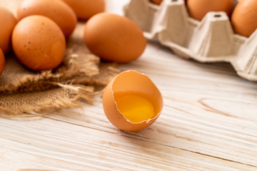 Brown eggs with one broken and egg yolk