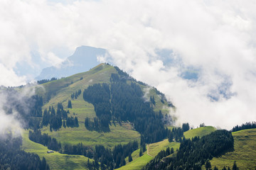 Naklejka premium Alpine view of Rigi mountain range terrain on a cloudy day with clouds touching ground in Central Switzerland