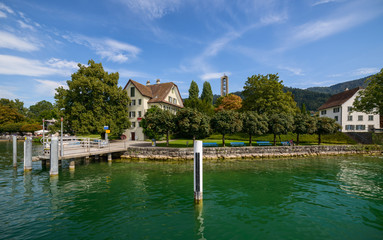 Obraz premium View from ship boat ferry arriving to / departing from Oberwil bei Zug village on Lake Zug in Central Switzerland