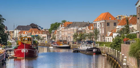 Fotobehang Panorama of a canal with old ships and historical houses in Zwolle © venemama