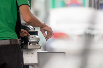 Pumping equipment gas at gas station. Close up of a hand holding fuel nozzle