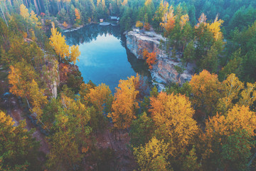 Fototapeta na wymiar Aerial view of the beautiful lake in the autumn forest. Granite lakeshore