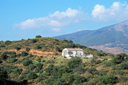View across countryside towards the Sierra de Mijas mountains with a traditional Spanish finca in the foreground near Fuengirola, Spain.