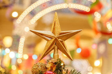 Fototapeta na wymiar A Christmas decorative - star on the top of A Christmas tree with a beautiful bokeh background