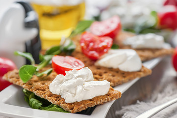 Burato cheese toasts with tomatoes and green salad on a white plate. The concept of healthy eating