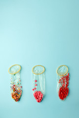 Condoms filled with multicolored confetti and confectionary dressing on a pink background - the...