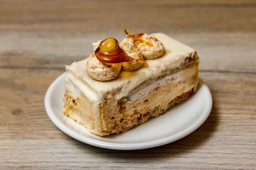Homemade decorative cake on a white plate and wooden table 