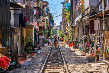 Woman is making a picture of Hanoi city railway Perspective view running along narrow street with houses in Vietnam - obrazy, fototapety, plakaty