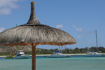Beach umbrella against the sky of the ocean and yachts