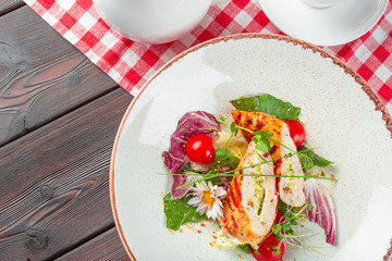 Fresh salad with chicken breast, arugula and tomato on a plate