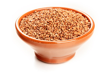 A photo of raw buckwheat in an earthenware bowl on a white background with a place for text