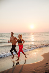 Man and Woman Running on Sandy beach