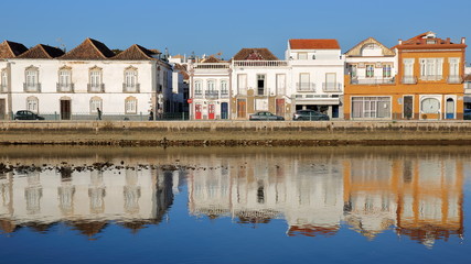 Fototapeta na wymiar Historical buildings located on Jacques Pessoa street and reflected in the river Rio Gilao, Tavira, Algarve, Portugal