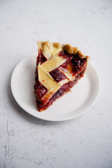 A slice of berry pie on a white plate