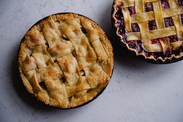 Apple pie and pie with berries on concrete background