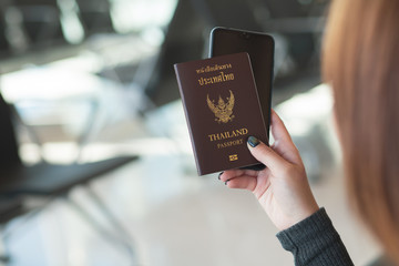 Travel concept. Closeup of woman hand holding Thai passport ready to boarding..
