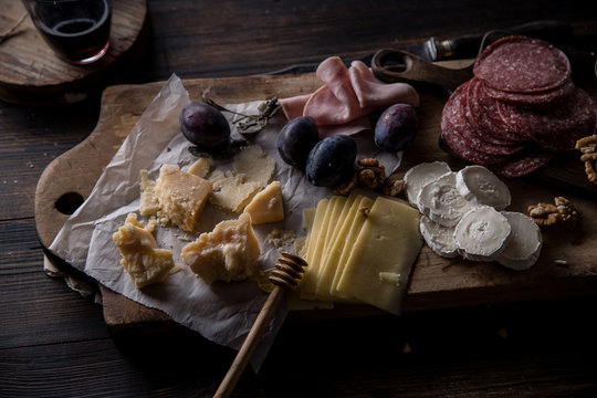 Cheese and meat board, snacks for wine with walnuts and honey