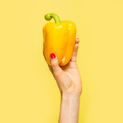Yellow pepper in hand. Yellow on yellow