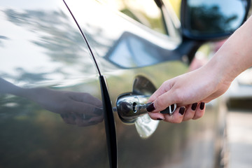 Close up woman hand opening car door..