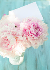  bouquet of peonies on a blue, wooden background. greeting card, spring concept.