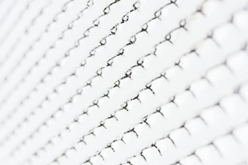 Rabitz mesh fence covered with snow. White background texture