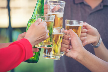 Young People toasting and cheer beer glasses,drink at bar party.Happy hour or chill out time,group of friends drunk from beverage(beer,wine,coctail)