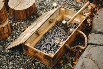 wooden box with big nails and a hammer on the street