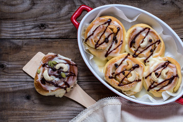 sinabon with cream cheese and cream, chocolate and cashew nuts on wooden background