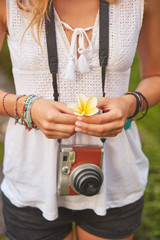 Girl posing with retro vintage camera outdoors.