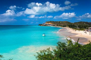 Tropical beach at Antigua island in Caribbean with white sand, turquoise ocean water and blue sky - obrazy, fototapety, plakaty