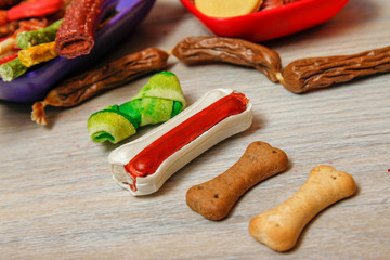 Delicious for dogs or dog's snacks. Dental and other bones, biscuits, chewy sticks and dry dog food in plastic bowls in various of colors.