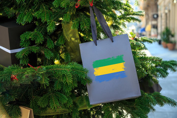 Gabon flag printed on a Christmas shopping bag. Close up of a shopping bag as a decoration on a...