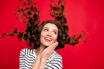 Close up  portrait of pretty charming glad attractive she her girl satisfied with salon procedures arms together hair flies  wearing white striped casual sweater on red vivid bright background