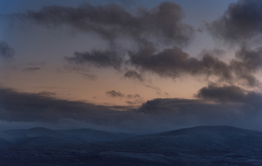 Winter cloudy sunset in snow Agarmysh mountains