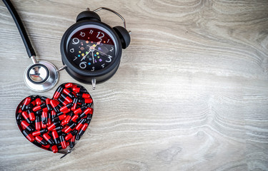 Black alarm clock and Love medical pills